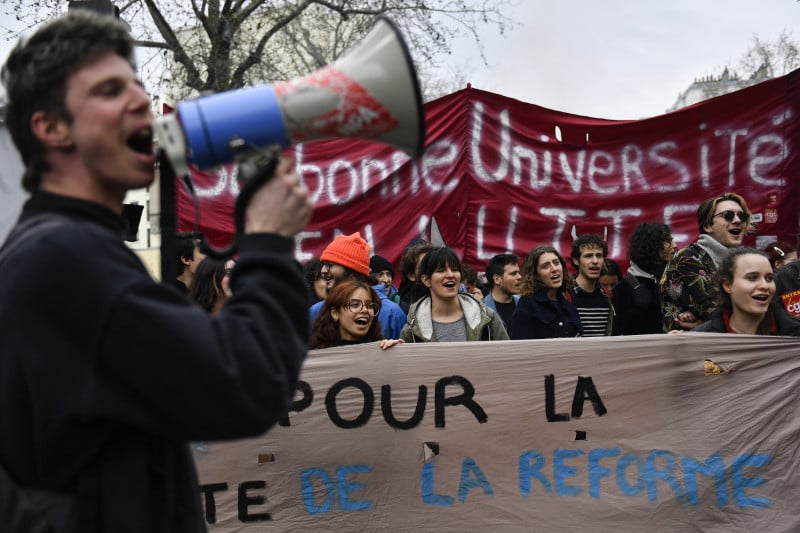 Autoridades se prepararam para um n&uacute;mero at&eacute; tr&ecirc;s vezes maior de estudantes nas ruas de cidades francesas

University students march during a demonstration after the government pushed a pensions reform through parliament without a vote, using the article 49.3 of the constitution, in Paris on March 28, 2023. - France faces another day of strikes and protests nearly two weeks after the president bypassed parliament to pass a pensions overhaul that is sparking turmoil in the country, with unions vowing no let-up in mass protests to get the government to back down. The day of action is the tenth such mobilisation since protests started in mid-January against the law, which includes raising the retirement age from 62 to 64. (Photo by JULIEN DE ROSA / AFP)