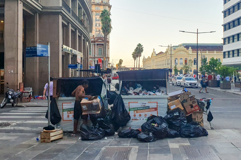 Catador busca materiais recicláveis em equipamento de descarte próximo da prefeitura de Porto Alegre