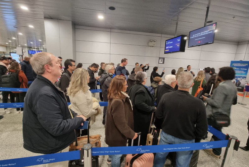Passageiros formam fila para acessar o portão de embarque para a viagem de três horas