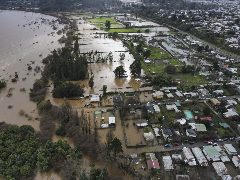  Aerial view of the town of Hualqui, some 30 km south of Concepcion, in central Chile, taken on June 25, 2023, after heavy rains in the region caused the Biobio river to overflow. - Rains in central Chile have left two people dead while six are missing, 7,977 isolated and 3,383 have been left homeless, Interior Minister Carolina Toha reported on June 24. (Photo by GUILLERMO SALGADO / AFP)
      Caption