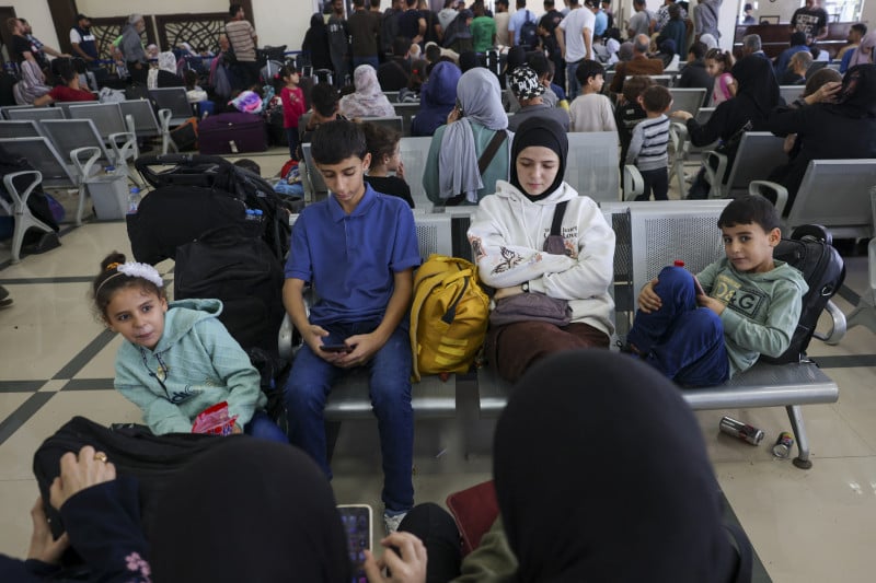 Palestinos com dupla nacionalidade e estrangeiros aguardam para atravessar a fronteira de Rafah