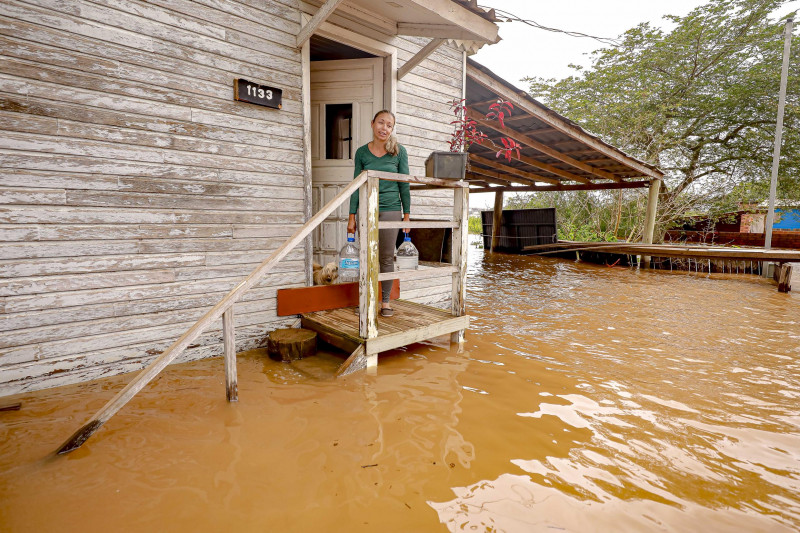 Famílias ainda nas casas na região das ilhas do Guaíba recebem ajuda em meio a água