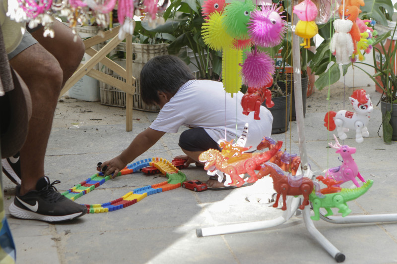 Criança acha brechas para brincar no mais fechado espaço, como esta na Rua da Praia