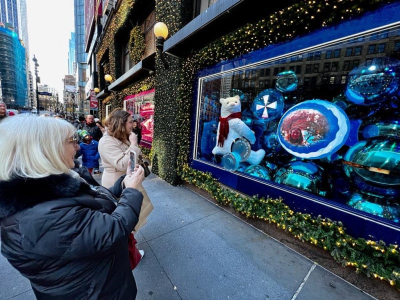 Pessoas se aglomeram em frente à vitrine para ver a imagem em balões metálicos