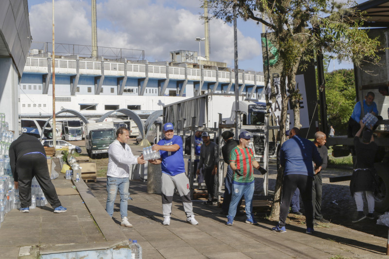 Voluntários descarregam águas de caminhão no Estádio Olímpico Monumental, bairro Medianeira