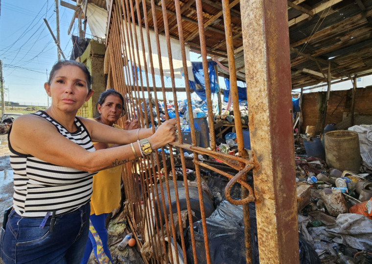 Janaína (e) e a irmã Solange em frente ao galpão onde trabalhavam: local ficou totalmente debaixo d'água