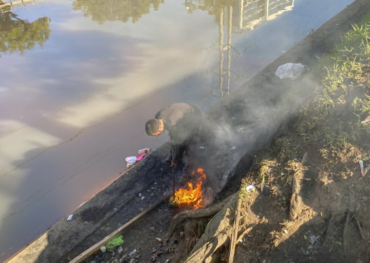 Fot&oacute;grafa T&acirc;nia Meinerz, do JC, flagrou homem queimando fios de cobre no Arroio Dil&uacute;vio