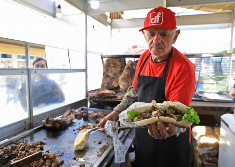 Carne é desfiada e o sanduíche preparado em frente à clientela
