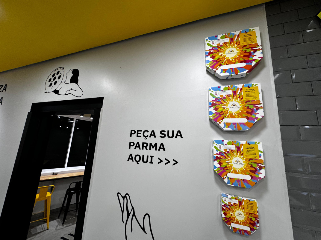 Embalagens das pizzas, expostas na parede, chamam a aten&ccedil;&atilde;o pela arte e pelo colorido | PATR&Iacute;CIA COMUNELLO/ESPECIAL/JC