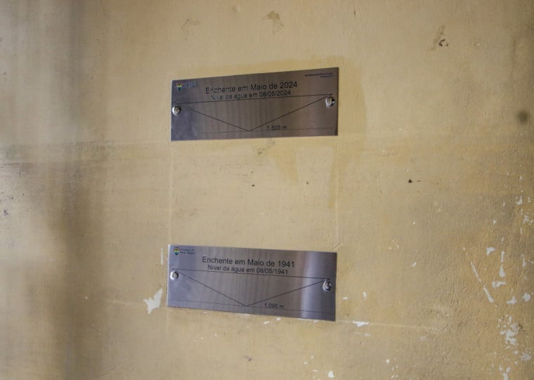 Placa no Mercado Público que marca até onde chegou a água na enchente de maio