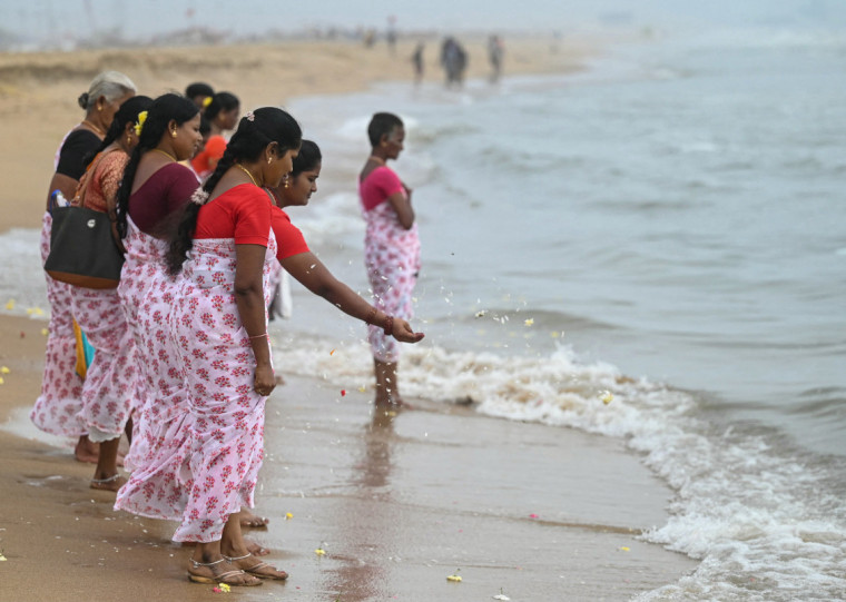 Women perform rituals during a ceremony held on the 20th anniversary for the victims of the 2004 Indian Ocean tsunami, at Pattinapakkam beach in Chennai on December 26, 2024. - Tearful mourners prayed on December 26, 2024, as ceremonies began across Asia to remember the 220,000 people who died two decades ago when a tsunami hit coastlines around the Indian Ocean, in one of the world's worst natural disasters. (Photo by R.Satish BABU / AFP)