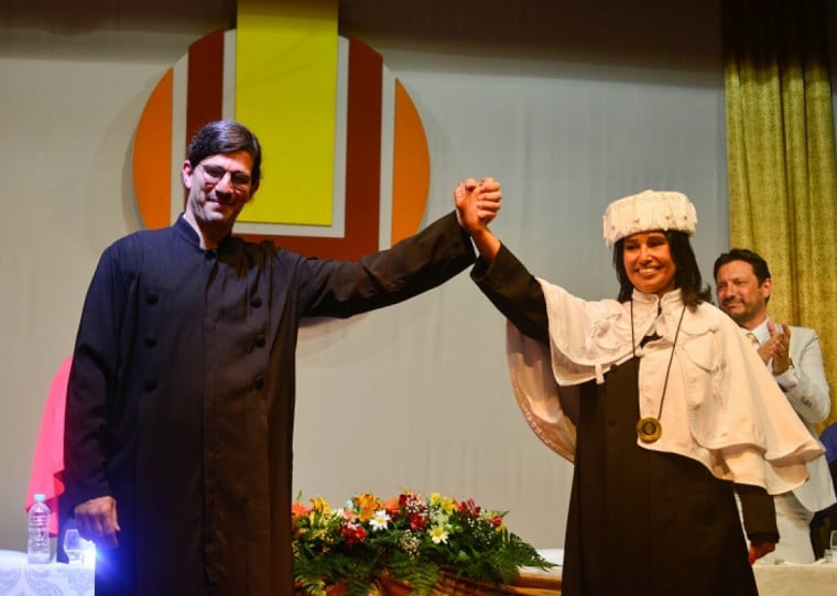 Gonçalves (d) recebeu os símbolos universitários das mãos do ex-reitor, Danilo Giroldo, que comandou a instituição de 2021 a 2025