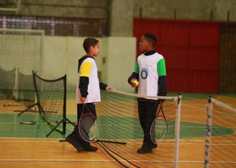 As aulas de tênis são realizadas em espaços públicos, como escolas e parques, com a presença de monitores