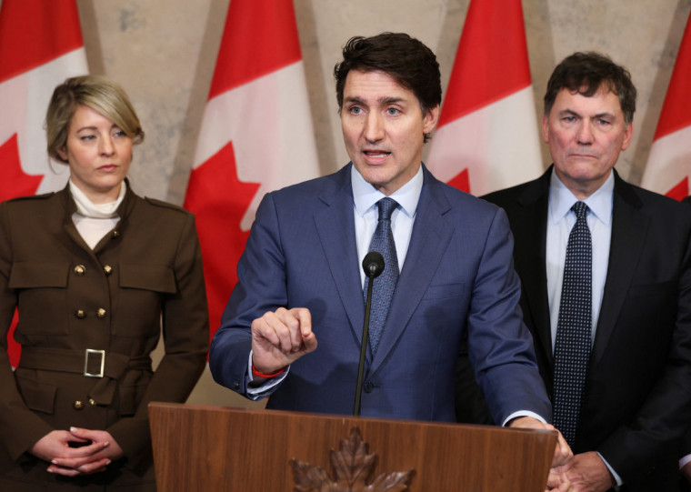  Canada's Prime Minister Justin Trudeau speaks during a news conference about the US tariffs against Canada on March 4, 2025 on Parliament Hill in Ottawa, as Foreign Minister Melanie Joly (L) and Minister of Finance and Intergovernmental Affairs Dominic Leblanc look on. Trudeau said that President Donald Trump imposed tariffs on Canada to destroy the country's economy to make it easier for the United States to annex its northern neighbor. The extraordinary warning about Trump's threat to Canadian sovereignty came as the US president delivered on his vow to impose 25 percent tariffs on all Canadian goods. (Photo by Dave Chan / AFP)
      Caption
