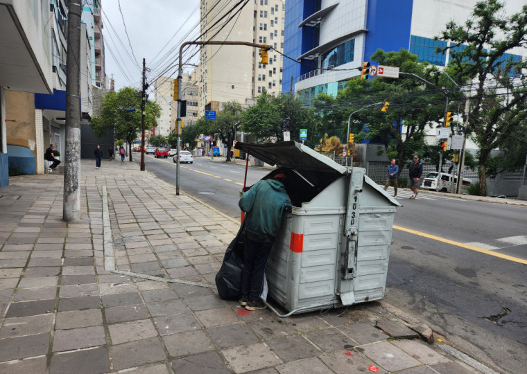 Catador de lixo revira contêiner de resíduos orgânicos em Porto Alegre