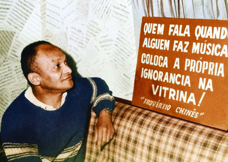 Rubens Santos no Clube dos Cozinheiros, diante do cartaz que se tornou folclórico na boemia da Capital (1968)