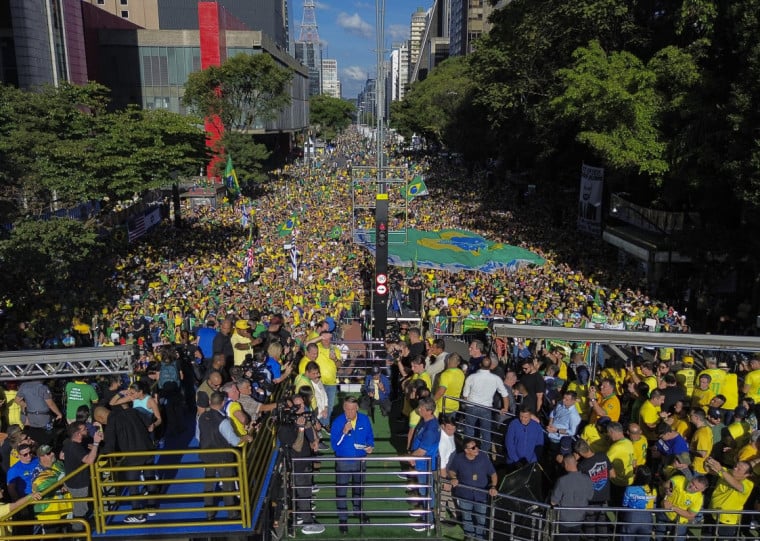 Vestindo azul e amarelo, Jair Bolsonaro (c) voltou a se defender das acusações de tentativa de golpe de Estado