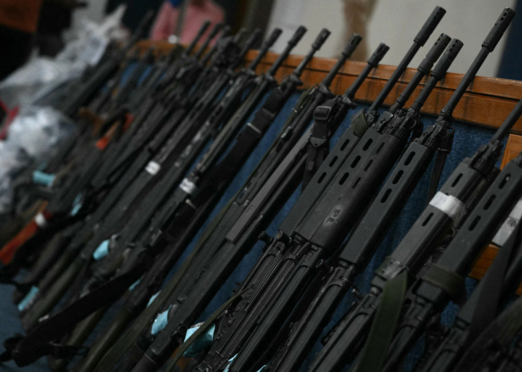  Assault rifles seized during the Operacao Contencao (Operation Containment) in the Penha Complex are displayed during a press conference at the Civil Police headquarters in Rio de Janeiro, Brazil, on October 29, 2025. The Rio de Janeiro public defender's office on Wednesday said a total of 132 people died in the bloodiest police raid against drug gangs in the Brazilian city's history, as grieving residents laid out dozens of bodies in the street. (Photo by Mauro PIMENTEL / AFP)