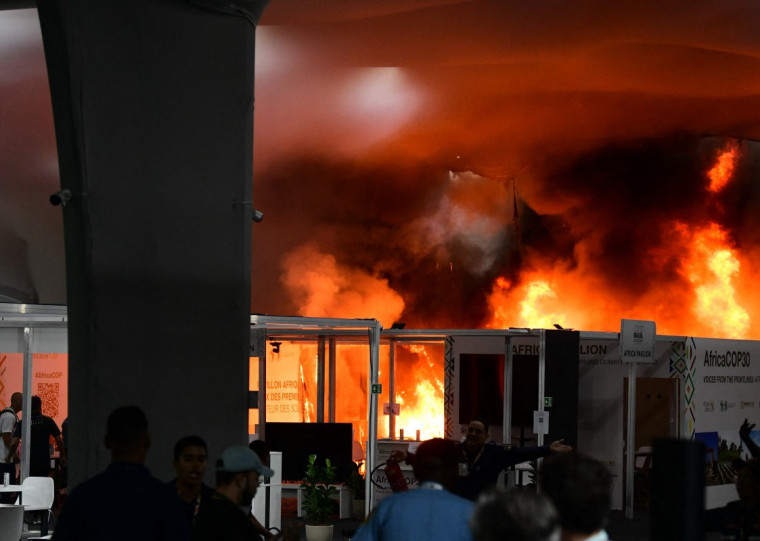  A fire burns in a pavilion during the COP30 UN Climate Change Conference in Belem, Para state, Brazil, on November 20, 2025. A fire erupted at a pavilion inside the venue of the UN's climate talks in Brazil on Thursday, prompting panicked delegates to run for the exits, AFP journalists said. Emergency crews rushed to try to put out the blaze as smoke engulfed the corridor. (Photo by JACQUELINE LISBOA / AFP)