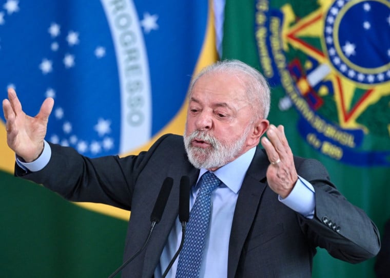  Brazil's President Luiz Inacio Lula da Silva (L) and his Finance Minister Fernando Haddad embrace during the signing ceremony of the new Income Tax Law at the Planalto Palace in Brasilia, on November 26, 2025. (Photo by Evaristo Sa / AFP)
      Caption