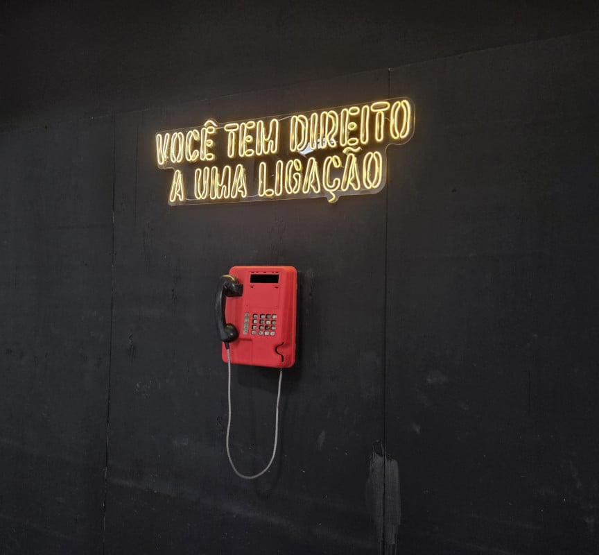 "Voc&ecirc; tem direito a uma liga&ccedil;&atilde;o" &eacute; mais um item da decora&ccedil;&atilde;o que remete &agrave; pris&atilde;o | J&uacute;lia Fernandes/Especial/JC