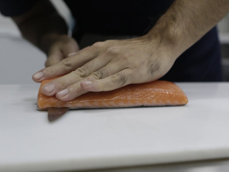 Segundo Jun, o processo de filetar o salm&atilde;o requer calma e disciplina<br />Foto: FABIOLA CORREA/JC