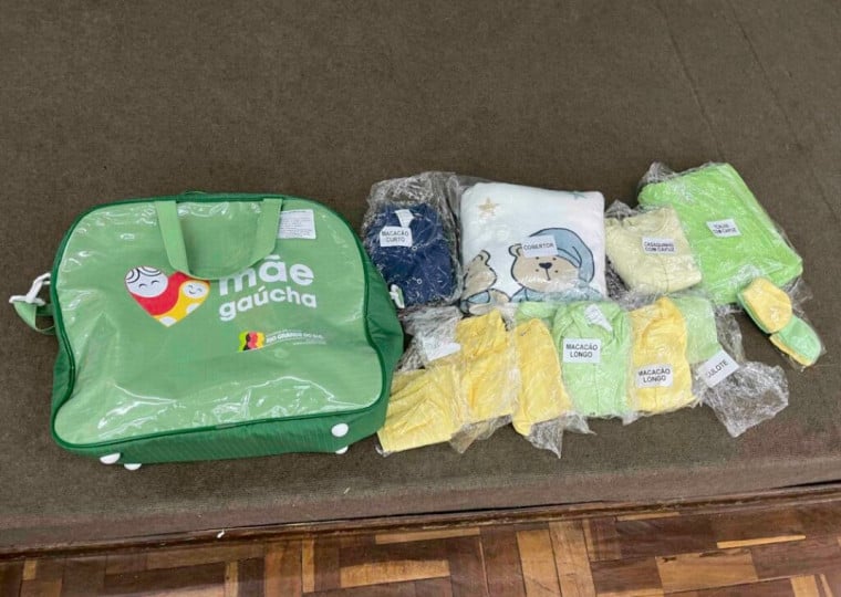 Cada kit enxoval é composto por um cobertor, toalha de banho com capuz, casaquinho de moletom, macacões longos e curtos, bodies, culotes, meias e uma bolsa maternidade