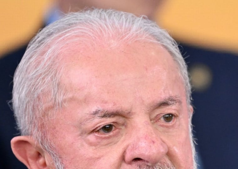  Brazilian President Luiz Inacio Lula da Silva gestures during the swearing-in ceremony for the new Minister of the Secretariat for Institutional Relations, Jose Guimaraes (out of frame), at the Planalto Palace in Brasilia on April 14, 2026. (Photo by Evaristo Sa / AFP)
      Caption