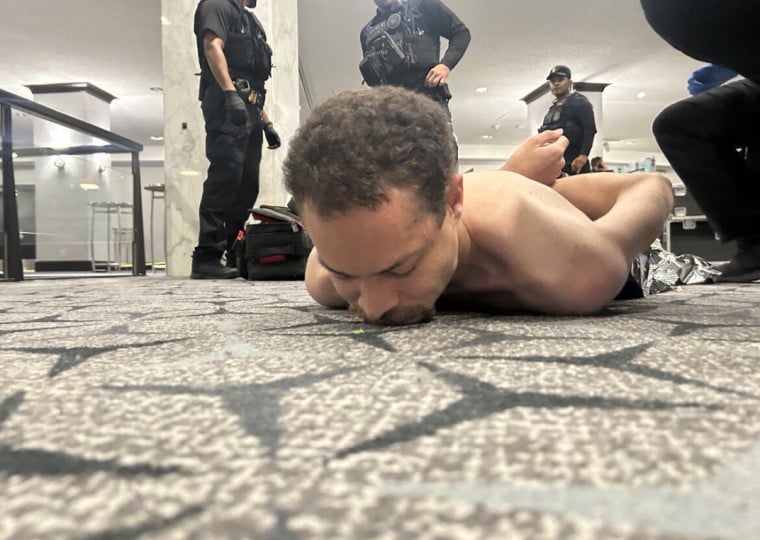 Foto do suspeito sob custódia, compartilhada por Donald Trump