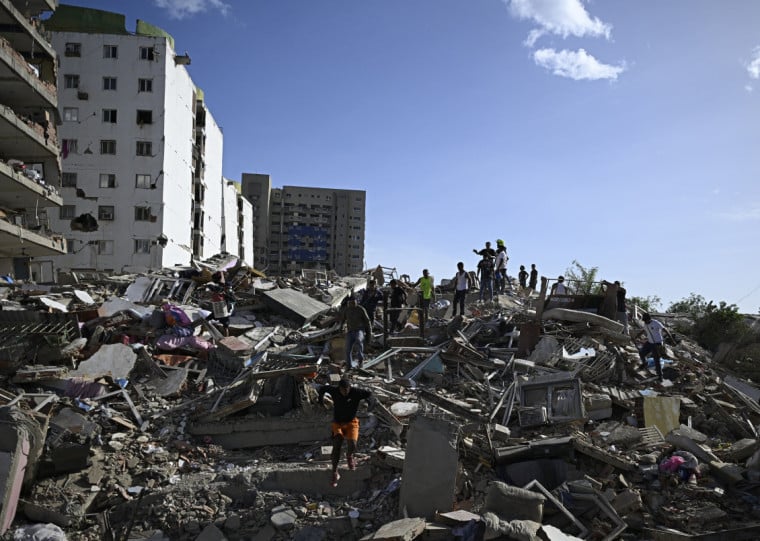  People search for survivors while others try to salvage belongings in a collapsed building following an earthquake in Catia La Mar, La Guaira state, some 30km north-west of Caracas, on June 25, 2026. A twin earthquake that was Venezuela's largest in over a century has killed at least 164 people and destroyed multiple buildings near the capital, where residents searched on June 25 for missing relatives. (Photo by Federico PARRA / AFP)