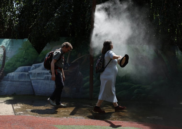  Local residents enjoy a mist spray at a parc in Pantin, north-east of Paris on June 28, 2026, as France experiences a heatwave. France will no longer have any departments under a red heatwave alert on June 29, 2026, with 39 departments under an orange alert, 19 of which are due to the risk of thunderstorms, Meteo-France announced on June 28, 2026. (Photo by Charlotte SIEMON / AFP)