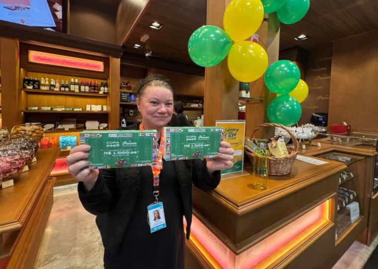 Cecilia mostra caixa de bolinhas de chocolate com cupom premiado da seleção campeã