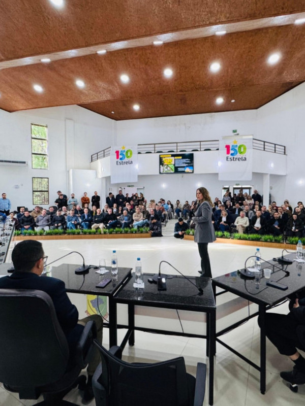 Ministro do Turismo em visita oficial, acenando para a população local ou em reunião com autoridades.
