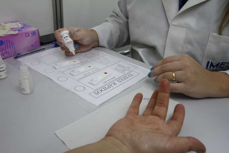 Com um aparelho, gotas de sangue são coletadas e colocadas em contato com um reagente. O resultado fica pronto em 20 minutos